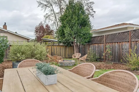 a backyard of a house with table and chairs