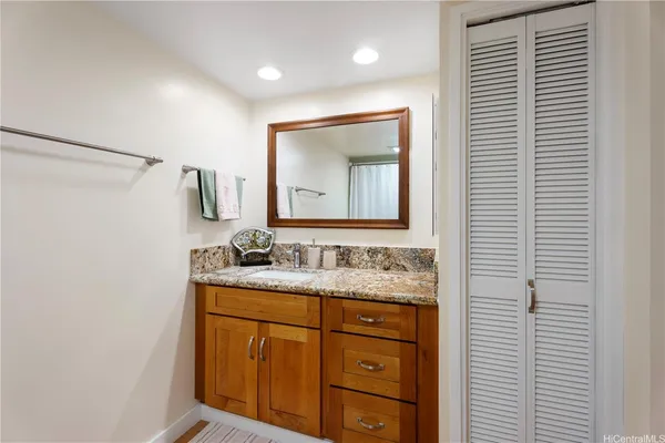 a bathroom with a granite countertop sink toilet and mirror