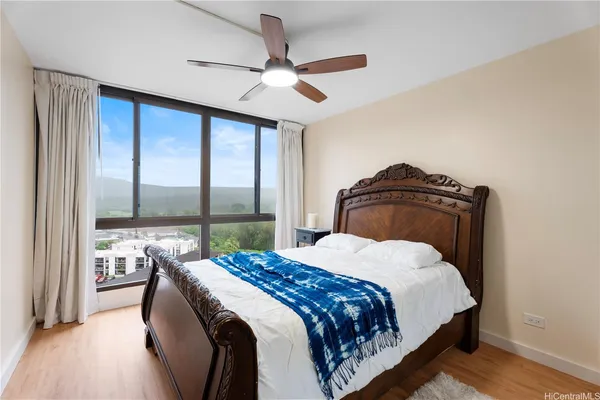 a bedroom with a bed and a large window