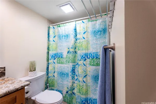 a bathroom with a shower curtain and a toilet