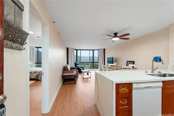 a view of a kitchen counter top space a sink wooden floor and a living room
