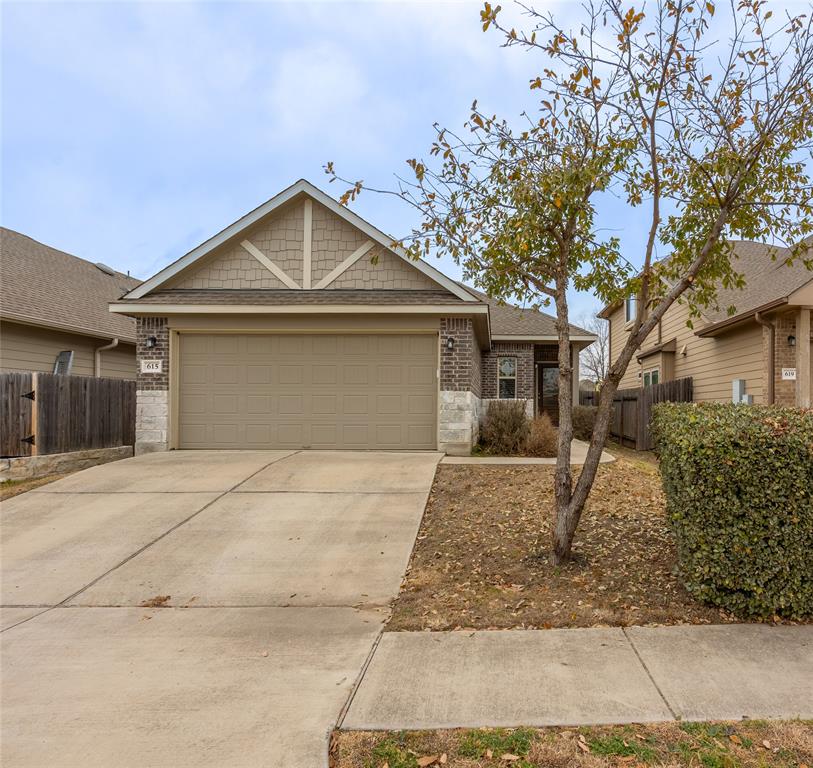 615 Stampede Road San Marcos, TX 78666 - Photo 2 of 26 A welcoming facade showcases brick and siding accents, with a tidy lawn and driveway leading to an integrated garage.