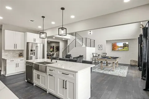a large kitchen with cabinets a sink a counter space and stainless steel appliances