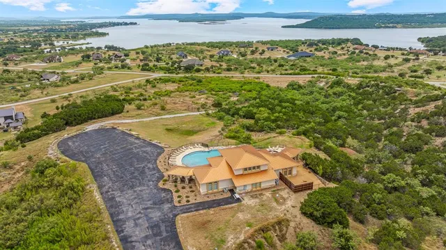 an aerial view of a swimming pool with a yard