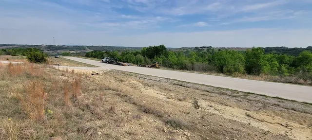 a view of a dry yard with wooden fence