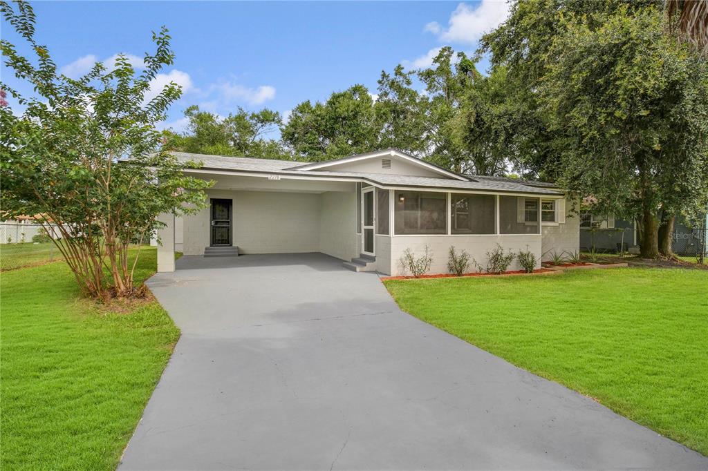 2218 SW Road Sanford, FL 32771 - Photo 1 of 1 a front view of a house with a yard and trees