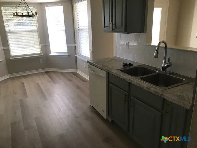a kitchen with a sink window and cabinets