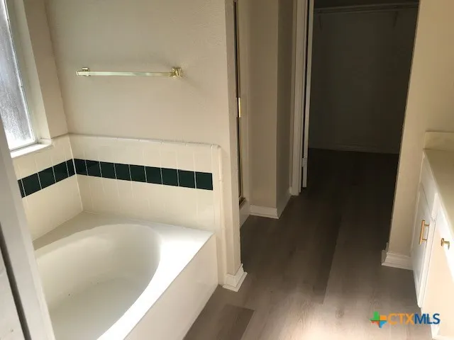 a bathroom with a bathtub and a window