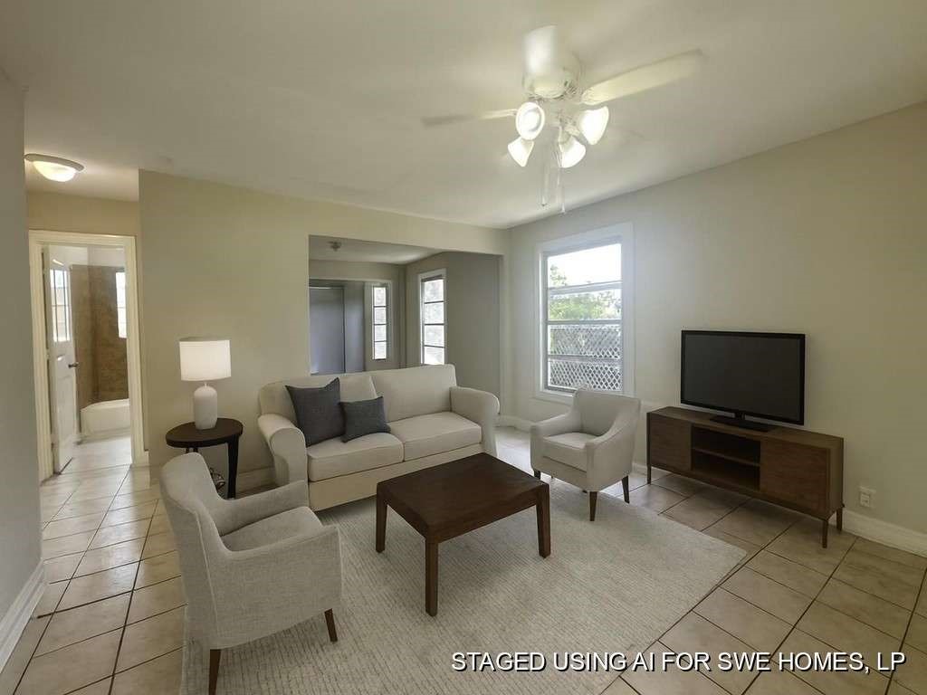 7410 Dallas Street Houston, TX 77011 - Photo 4 of 13 a living room with furniture a flat screen tv and a chandelier