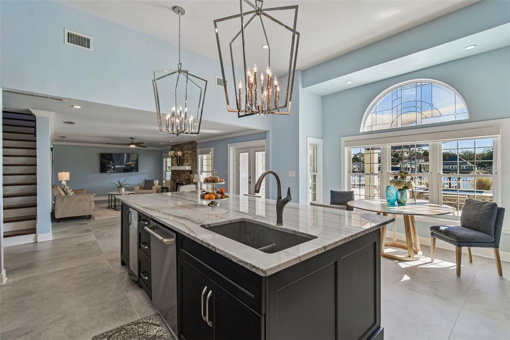 8025 Island Drive Port Richey, FL 34668 - Photo 31 of 67 a kitchen with stainless steel appliances granite countertop a sink a stove and a dining table