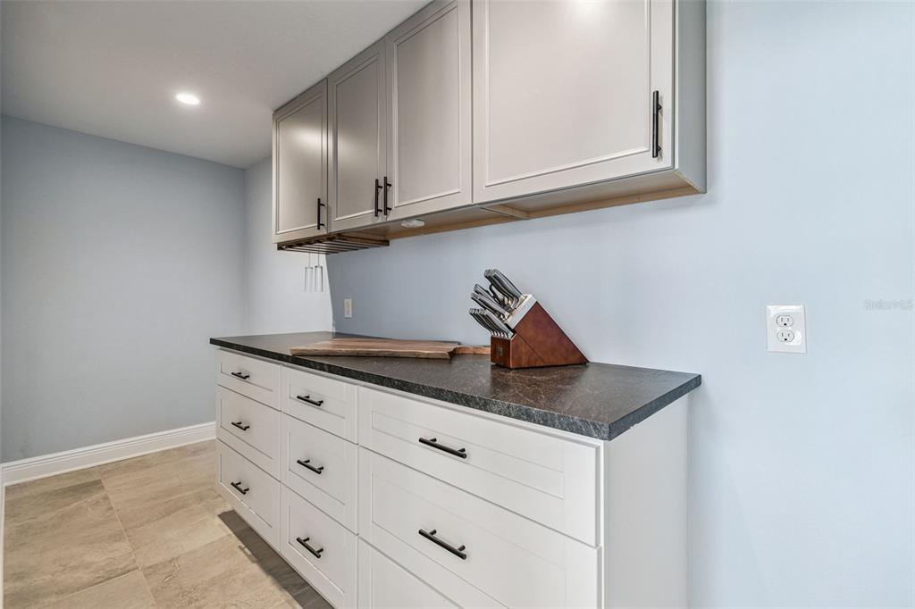 8025 Island Drive Port Richey, FL 34668 - Photo 33 of 67 a kitchen with granite countertop white cabinets and a sink
