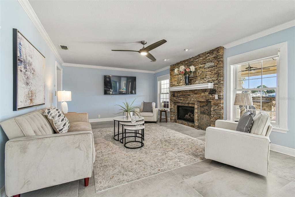 8025 Island Drive Port Richey, FL 34668 - Photo 36 of 67 a living room with furniture a fireplace and a large window