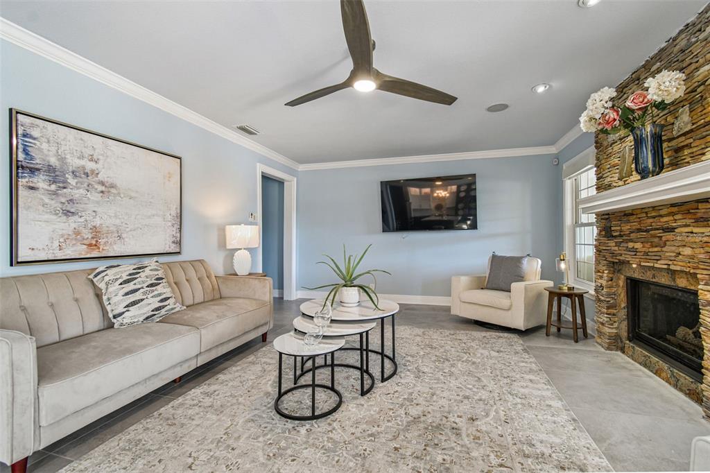 8025 Island Drive Port Richey, FL 34668 - Photo 37 of 67 a living room with furniture a fireplace and a flat screen tv
