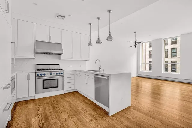 a kitchen with stainless steel appliances a stove top oven and a sink