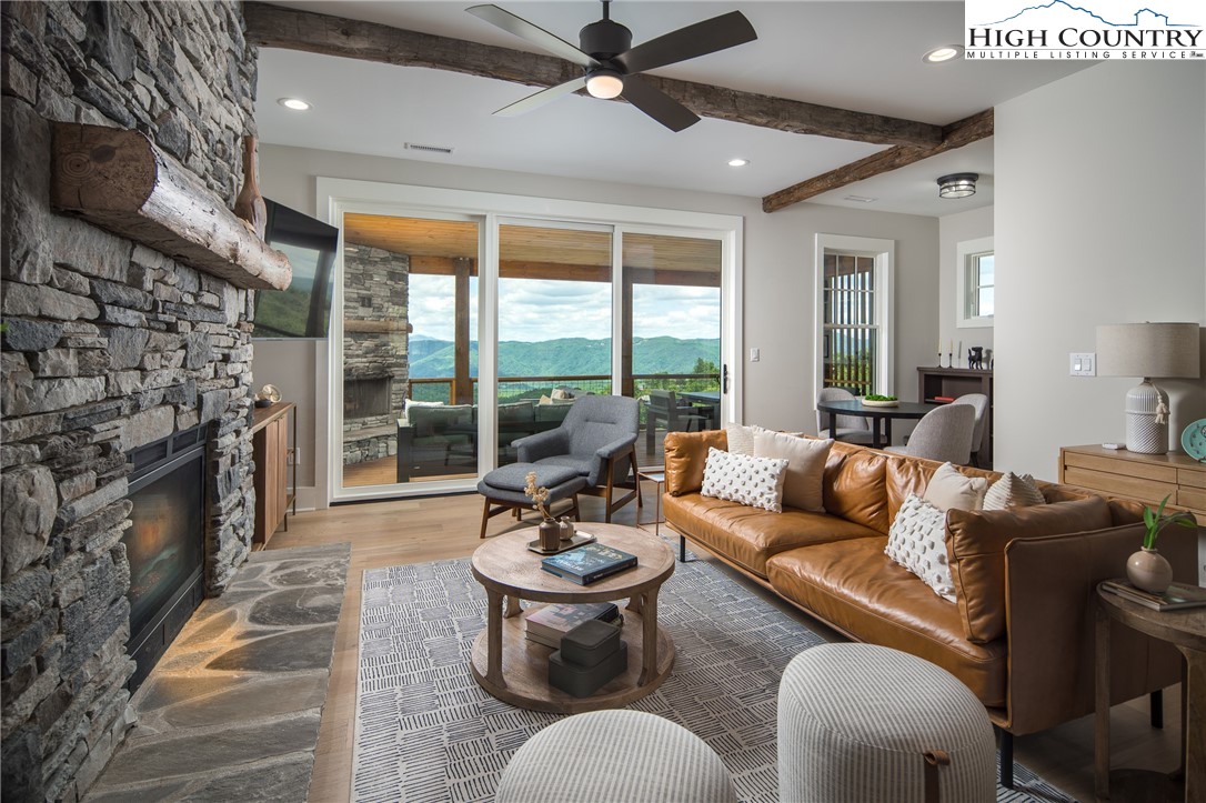 192 North Face Trail Boone, NC 28607 - Photo 2 of 38 a living room with furniture a fireplace and a floor to ceiling window