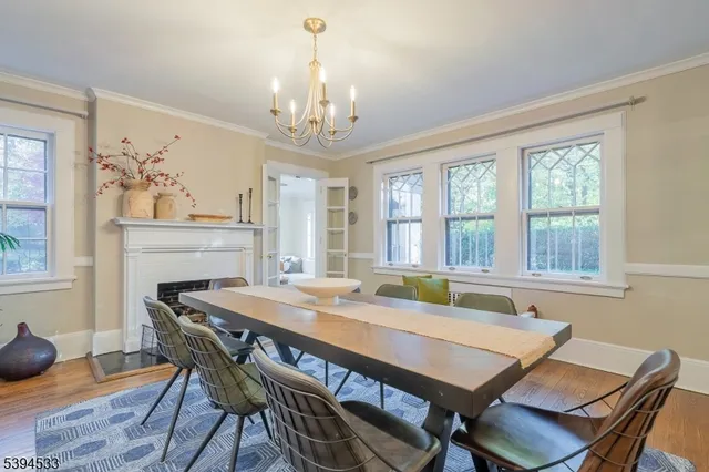 a view of a dining room with furniture a chandelier and wooden floor