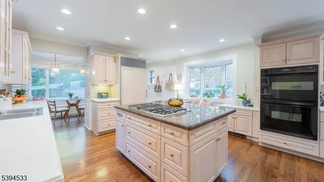 a kitchen with stainless steel appliances granite countertop a stove and a wooden floors