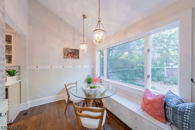a dining room with furniture a chandelier and wooden floor