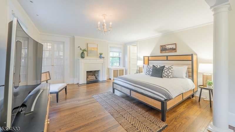 16 W Road Short Hills, NJ 07078 - Photo 23 of 47 a bedroom with a bed wooden floor and a fireplace