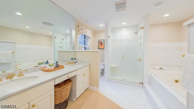 a bathroom with a sink double vanity granite tub shower and a mirror