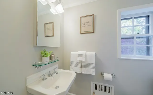 a bathroom with a sink a mirror and a window