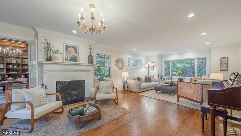 16 W Road Short Hills, NJ 07078 - Photo 7 of 47 a living room with furniture a chandelier and a fireplace