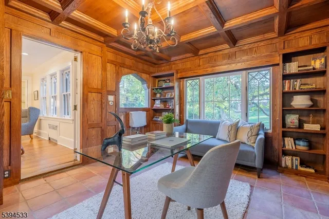 a living room with furniture a bookshelf and a large window