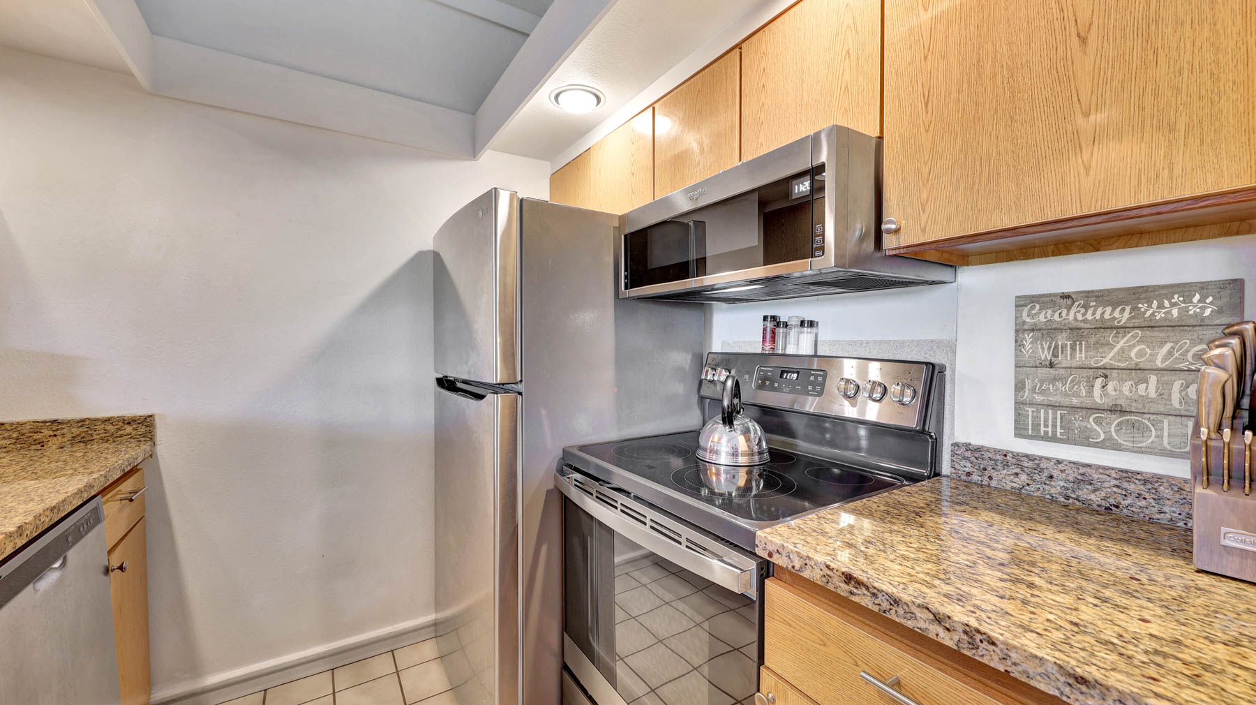 2253 Poipu Road, Unit 218 Koloa, HI 96756 - Photo 11 of 23 a kitchen with stainless steel appliances granite countertop a stove a microwave and a refrigerator