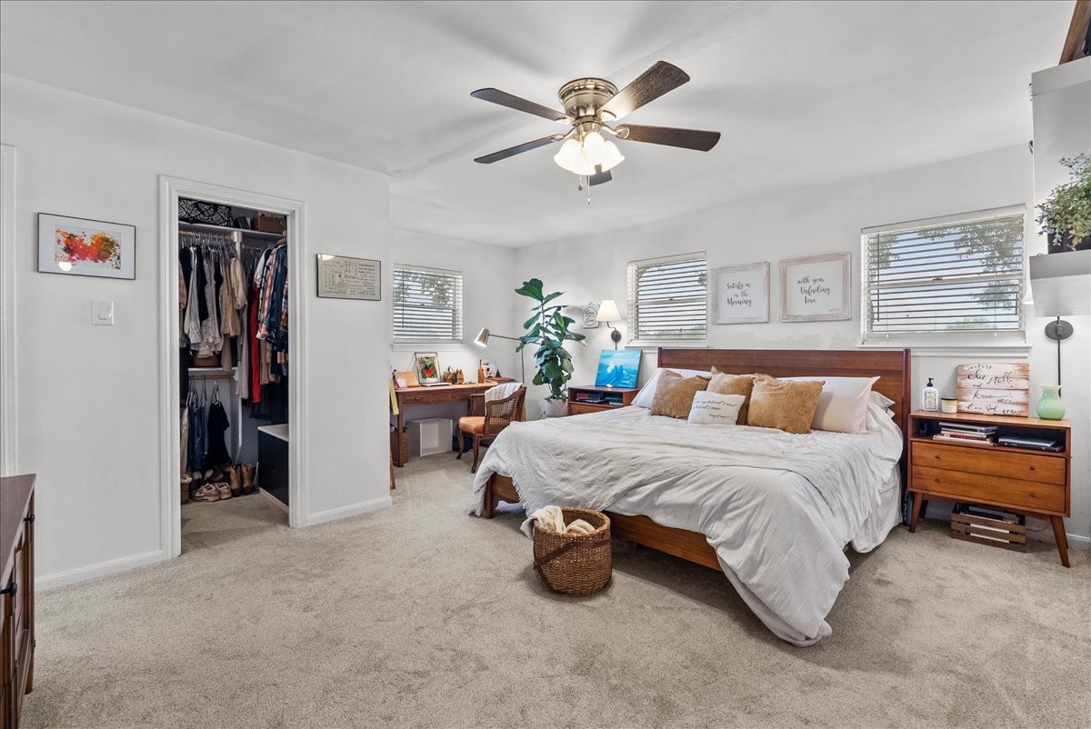 10803 Oberrender Road Needville, TX 77461 - Photo 17 of 36 a spacious bedroom with a bed and a chandelier