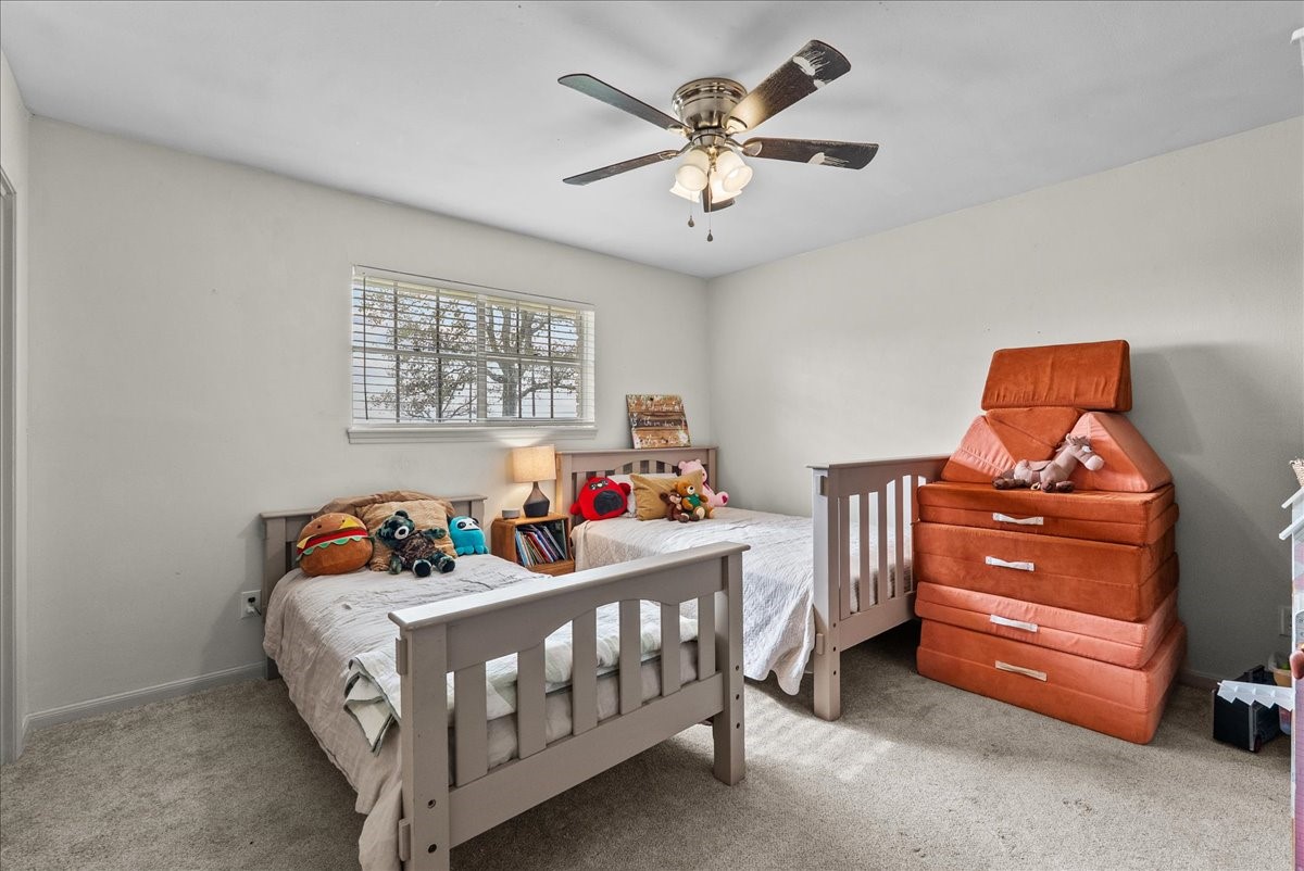 10803 Oberrender Road Needville, TX 77461 - Photo 26 of 36 a bedroom with a bed and a chandelier