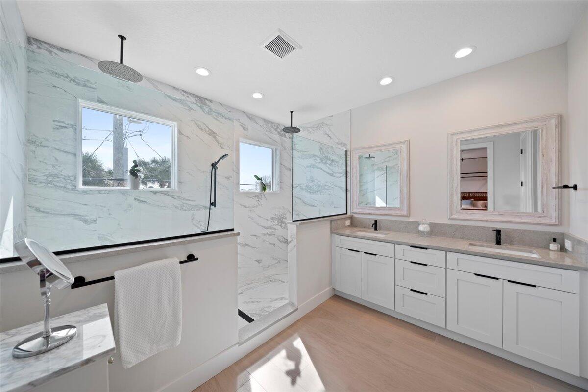 223 6th Avenue Indialantic, FL 32903 - Photo 10 of 26 a large bathroom with a double vanity sink a large mirror and shower