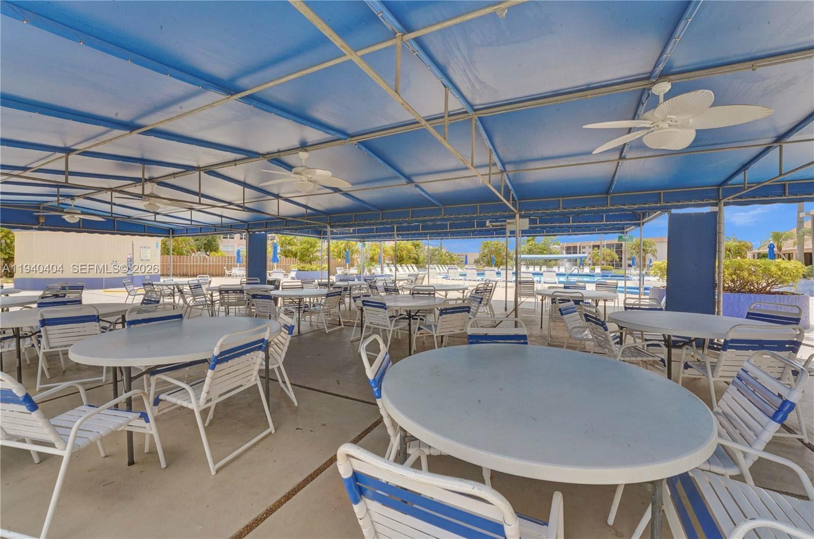 2541 North Nob Hill Road, Unit 309 Sunrise, FL 33322 - Photo 19 of 31 a dining room with furniture and a floor to ceiling window