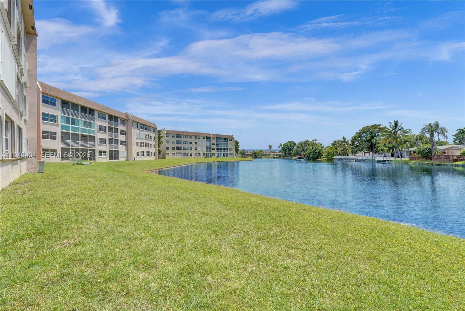 2541 North Nob Hill Road, Unit 309 Sunrise, FL 33322 - Photo 20 of 31 a view of a lake with a big yard and large trees
