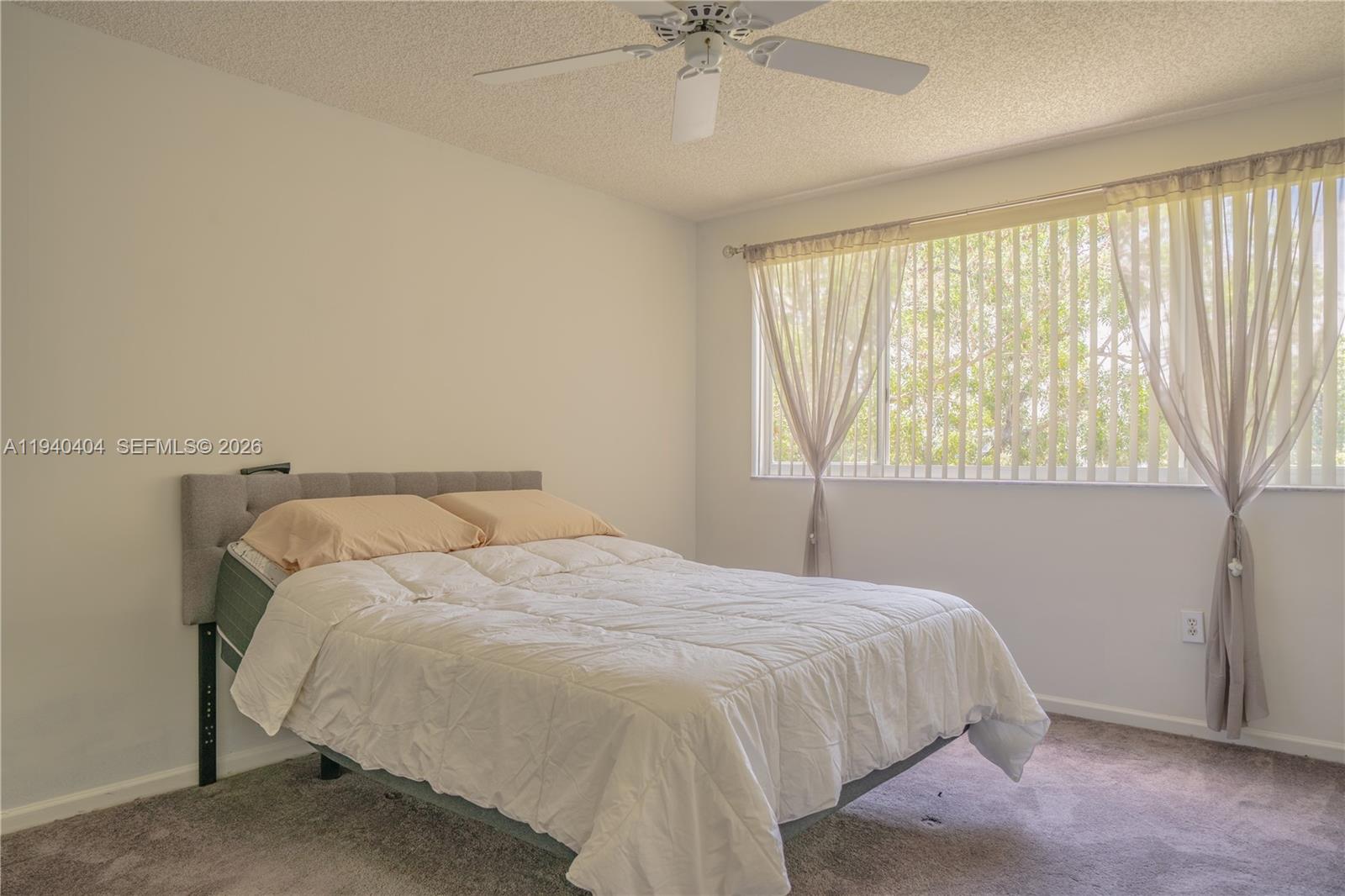 2541 North Nob Hill Road, Unit 309 Sunrise, FL 33322 - Photo 7 of 31 a bed sitting in a bedroom next to a window