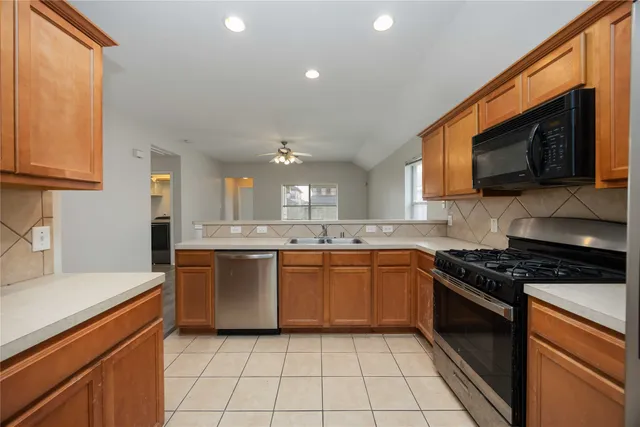 a kitchen with stainless steel appliances granite countertop a stove top oven a sink dishwasher and a microwave oven on the blue kitchen countertops