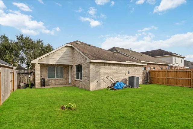 a view of a house with a big yard and large tree