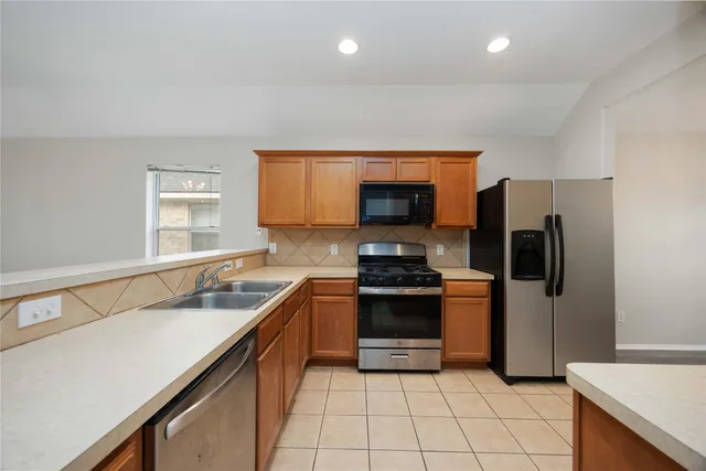 a kitchen with stainless steel appliances granite countertop a sink and a stove