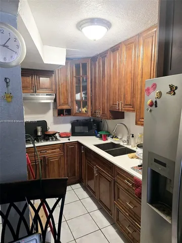 a kitchen with a stove a sink and cabinets