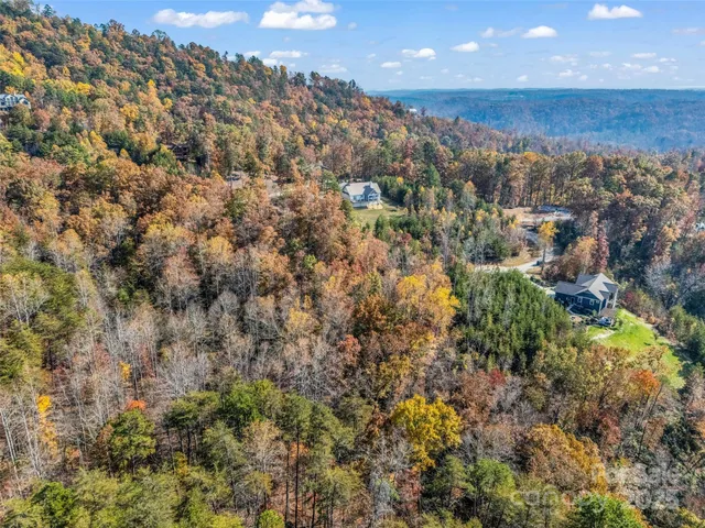an aerial view of house with yard and mountain in the back