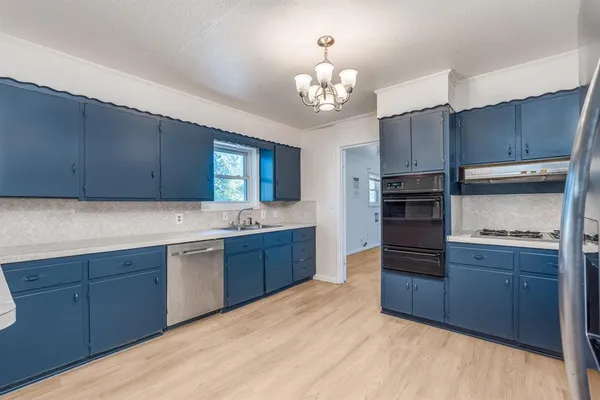 a kitchen with wooden floors and cabinets