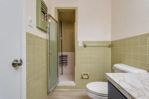 a bathroom with a granite countertop sink a toilet and shower