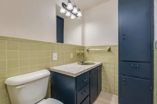 a bathroom with a granite countertop sink a toilet and a mirror