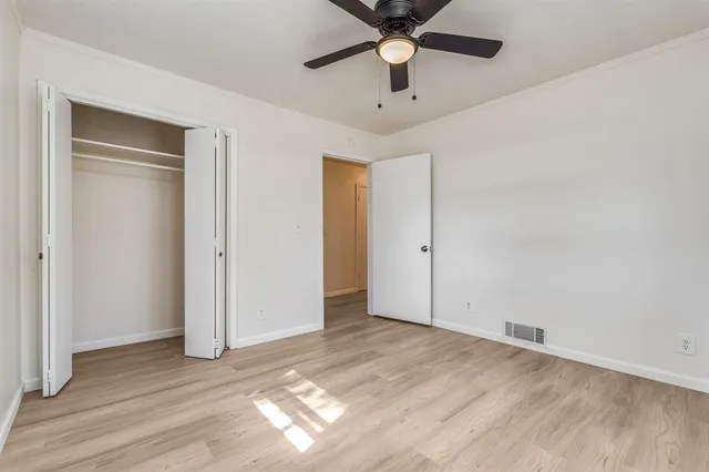 an empty room with a ceiling fan and wooden floor