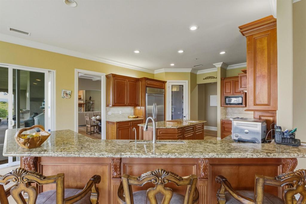 4712 Briana Court Fallbrook, CA 92028 - Photo 15 of 40 a kitchen with granite countertop sink and cabinets
