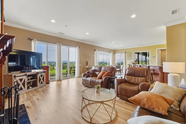 a living room with furniture kitchen view and large windows