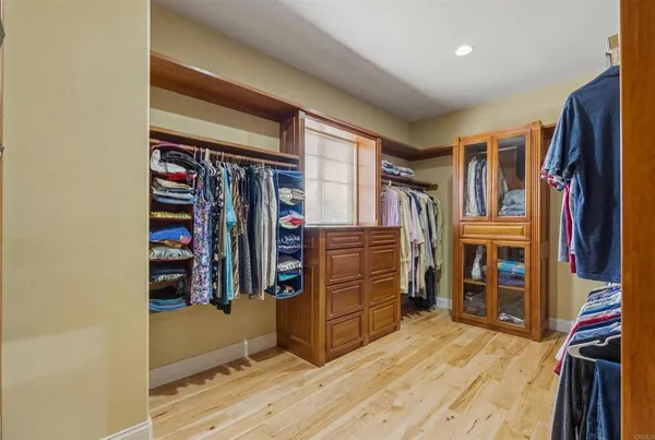 a view of walk in closet with clothes and shoes