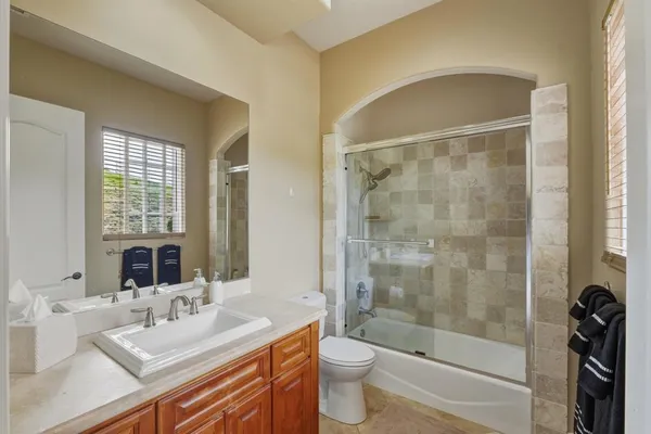 a bathroom with a sink a toilet and shower