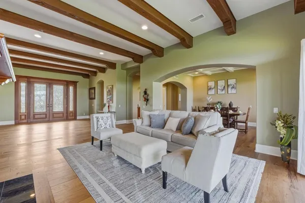 a living room with couches chairs and wooden floor