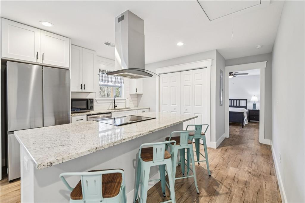 985 Timber Trail Austell, GA 30168 - Photo 5 of 15 a kitchen with granite countertop a table chairs microwave and refrigerator