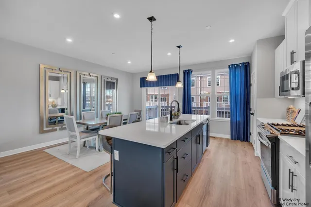 a kitchen with granite countertop a sink stove and wooden floor